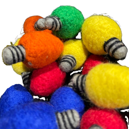 Bright wool felt holiday light bulb cat toys in red, green, yellow, blue, and orange with hand-stitched details, sprayed with CatnipTakeout catnip for playful batting and chasing.
