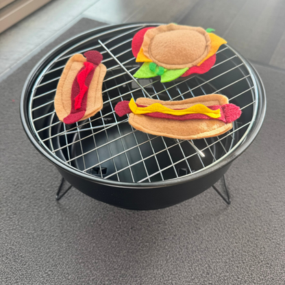 BBQ themed cat toys with cheeseburger and hot dogs styled on a tabletop grill for playful cat enrichment