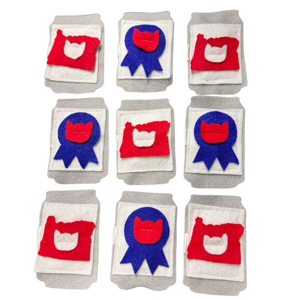 beer can catnip toys in PBR red patch and PNW Finest blue ribbon felt designs on gray felt cans