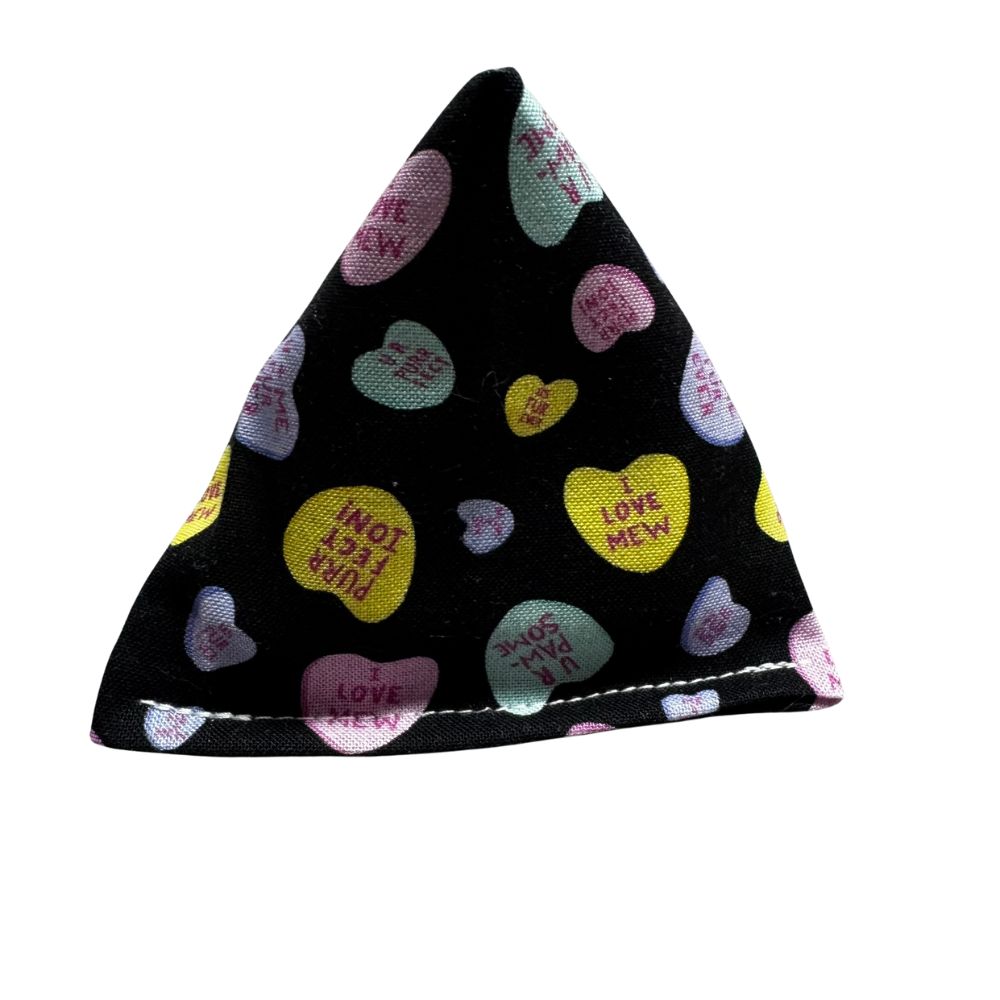 Handmade Happy Sack cat toy in black fabric with pastel candy hearts, pyramid-shaped and filled with signature premium catnip for interactive play. Made by CatnipTakeout.