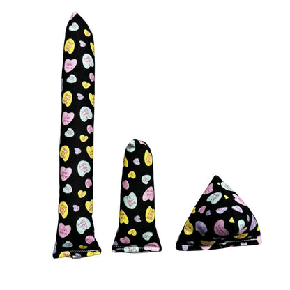 Group photo of handmade cat toys including a full-size kicker, mini kicker, and Happy Sack in black fabric with pastel candy hearts, filled with signature premium catnip. Made by CatnipTakeout.