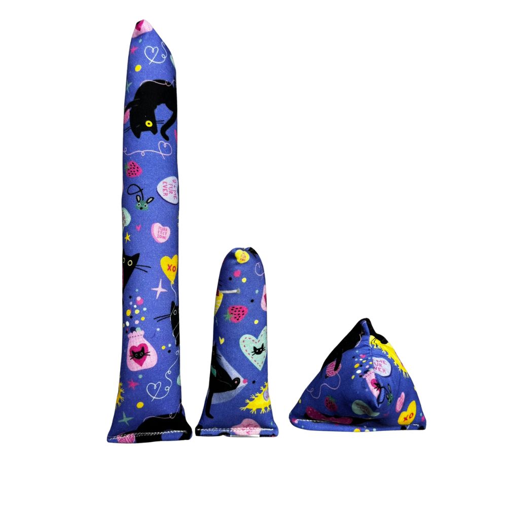 Group photo of handmade bluish/purple Valentine cat toys including a kicker, mini kicker, and Happy Sack, filled with signature premium catnip. Made by CatnipTakeout.