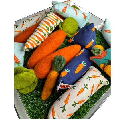 Carrot cat toy collection with wool carrots, carrot print kickers, and Happy Sacks arranged together