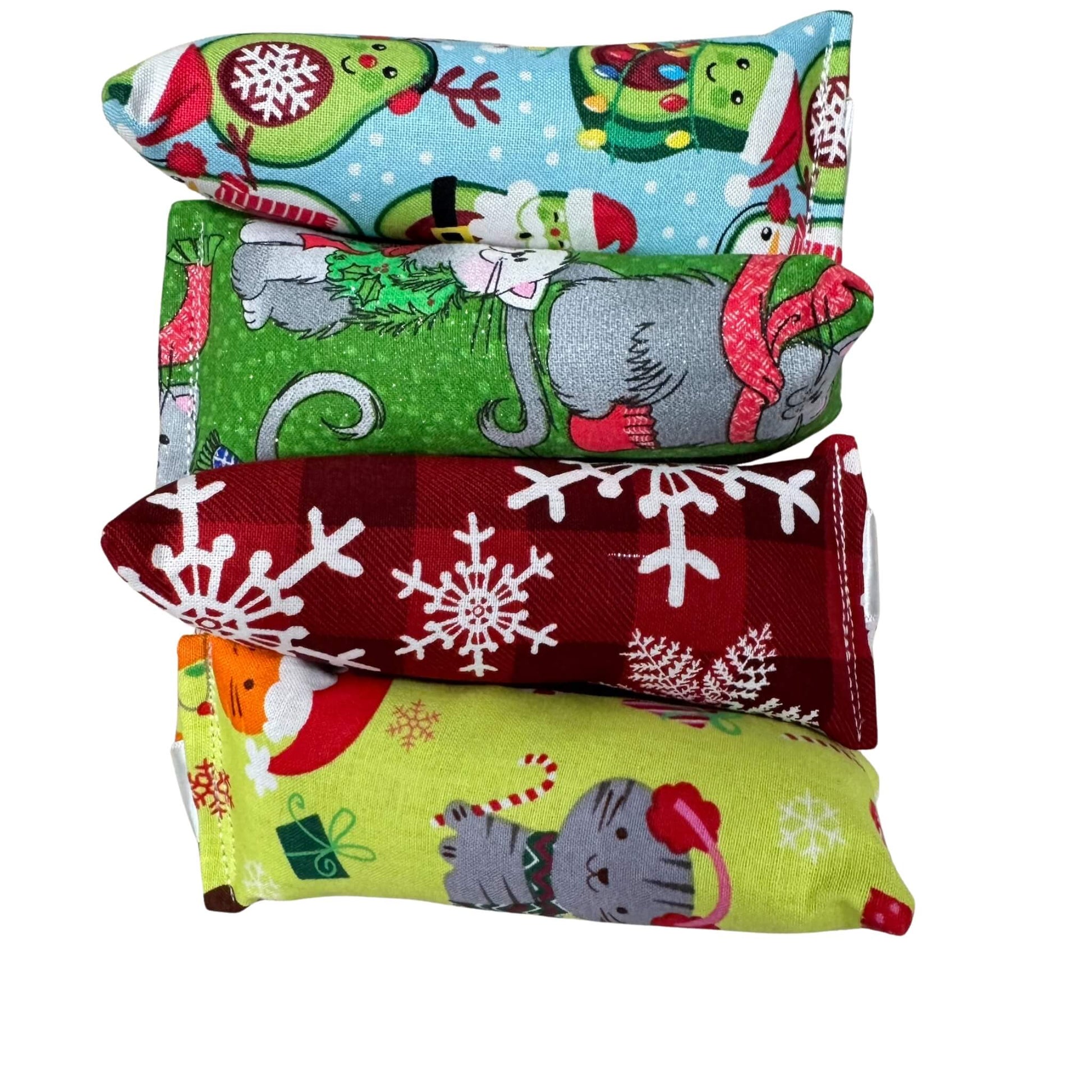 Christmas mini kicker cat toy with holiday fabric featuring snowflakes, cats, gifts, and avocados in scarves. Made by CatnipTakeout.