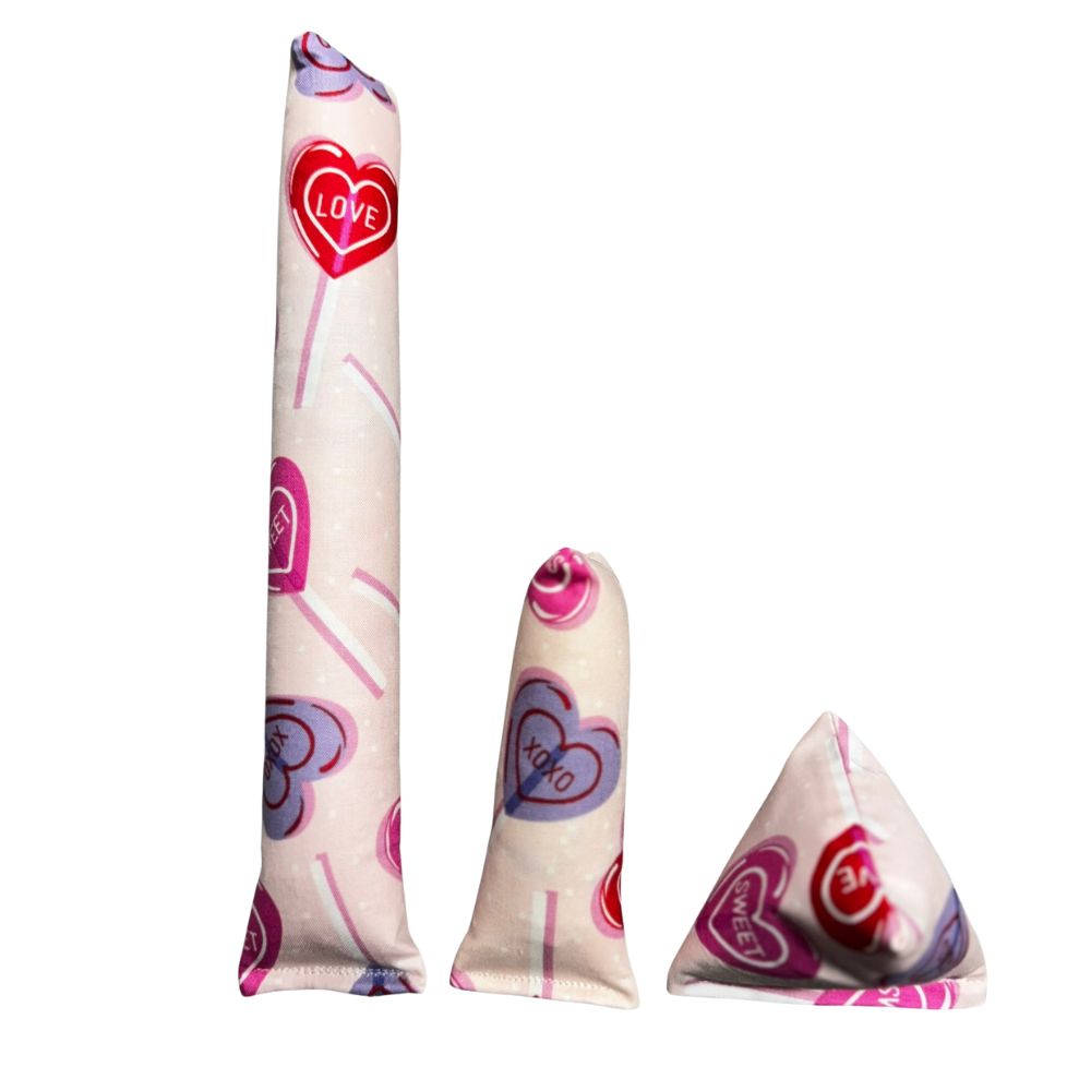 Group photo of handmade cat toys including a full-size kicker, mini kicker, and Happy Sack in light fabric with Valentine conversation hearts, filled with signature premium catnip. Made by CatnipTakeout.