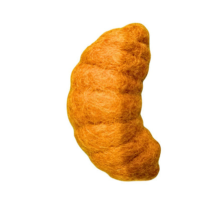 Side view of a croissant-shaped cat toy showing layered pastry texture and curved shape for interactive cat play.