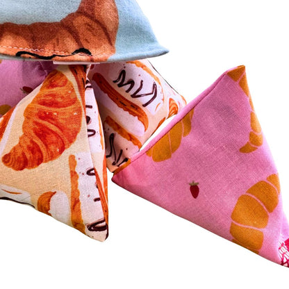 Croissant Happy Sack catnip cat toy by CatnipTakeout, pyramid-shaped soft fabric toy with pink croissant print and golden felt croissant topper, designed for kittens and interactive self-play