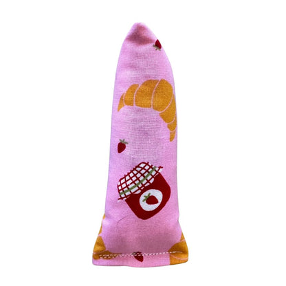 CatnipTakeout Croissant Mini Kicker Catnip Toy shown in a slim, elongated mini kicker shape designed for kittens and adult cats. Features pink bakery-themed fabric with illustrated croissants, strawberries, and jam jars. Durable construction sized for easy gripping, bunny kicks, and solo play, filled with CatnipTakeout’s signature aromatic catnip for long-lasting engagement.