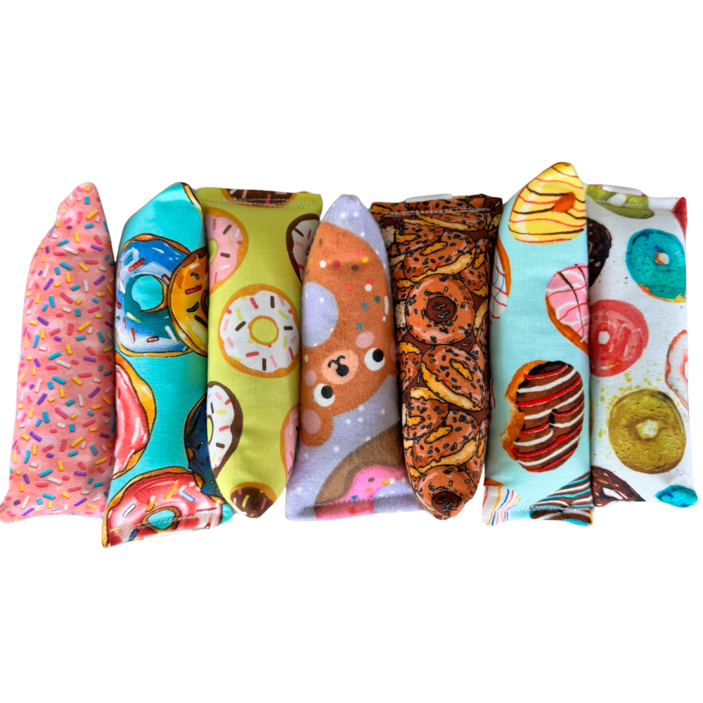Donut cat toys lined up in Happy Sack, Mini Kicker, and Kicker shapes for chase carry and kick play