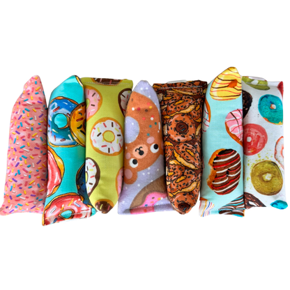 Donut cat toys lined up in Happy Sack, Mini Kicker, and Kicker shapes for chase carry and kick play