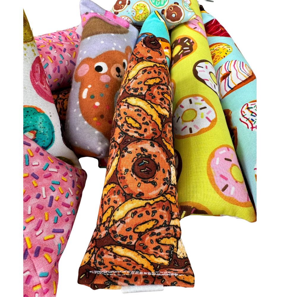Donut cat toy Mini Kicker shown in hand among other toys for grab carry and chase play