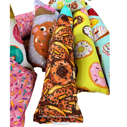 Donut cat toy Mini Kicker shown in hand among other toys for grab carry and chase play
