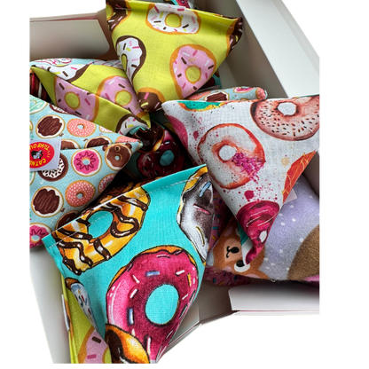 Donut cat toy Happy Sacks arranged inside a takeout box for giftable batting and pounce play