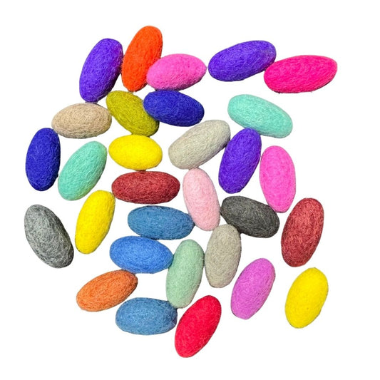 Colorful felt je;;y beans ( oval shaped)  in various sizes on a white background.