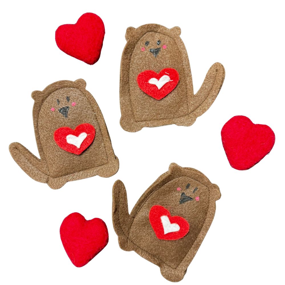 Close-up of handmade otter cat toy showing red heart felt detail, soft brown felt body, filled with premium catnip. Made by CatnipTakeout.
