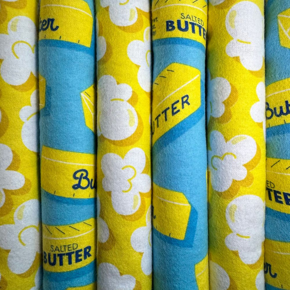 Handmade catnip kicker toys showing both popcorn print and butter print fabrics arranged side by side