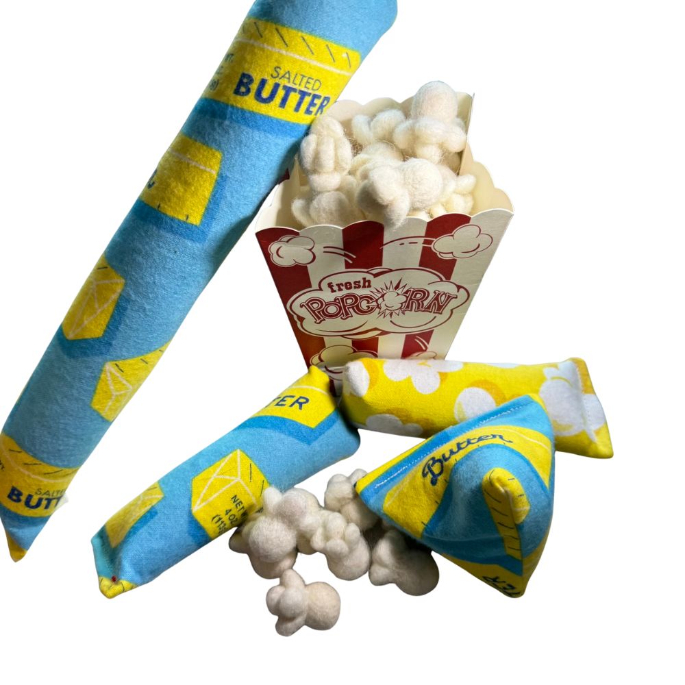 Popcorn and Butter -themed cat toys with mini kickers and popcorn pieces arranged around a popcorn box, sprayed with catnip, durable and handmade toys designed for interactive kicking, batting, and enrichment play for indoor cats.