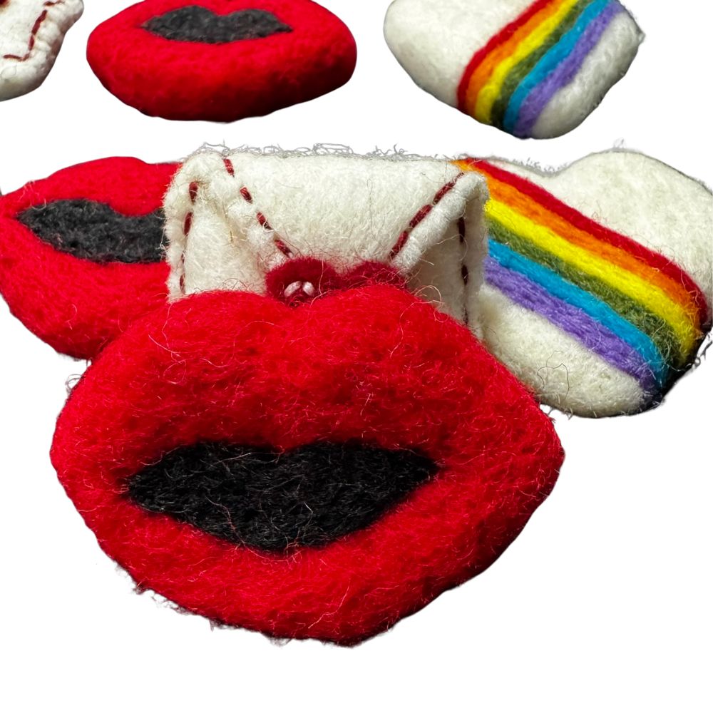 Close-up of red felt wool lips cat toy showing black felt center, handmade and sprayed with CatnipTakeout signature catnip spray.