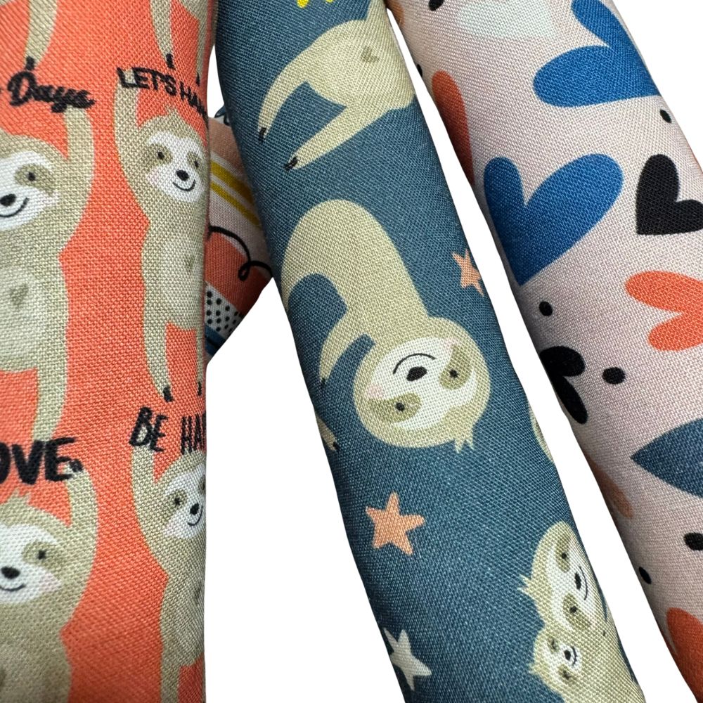 Close-up of handmade Sloth kicker cat toys highlighting cotton fabric prints, stitching, and long shape, each filled with signature premium catnip for active play. Made by CatnipTakeout.