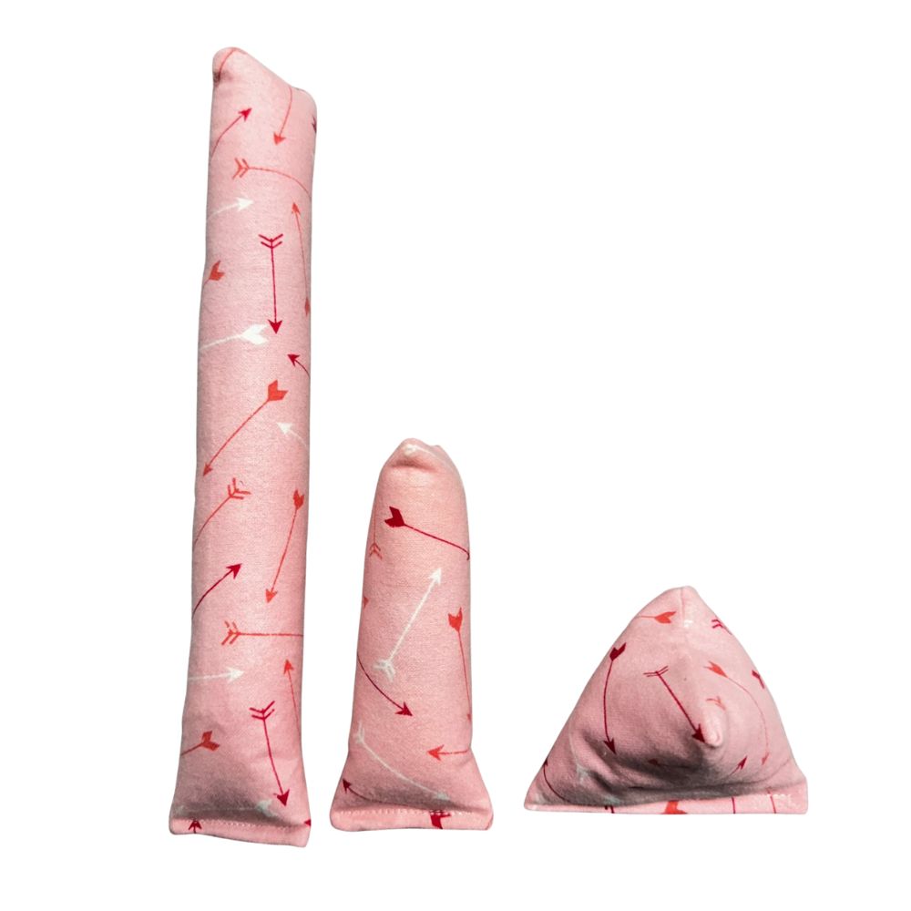 Group photo of three handmade Valentine arrows cat toys: one long Kicker, one Mini Kicker, and one pyramid Happy Sack in a soft pink arrows pattern, filled with signature premium catnip. Made by CatnipTakeout.
