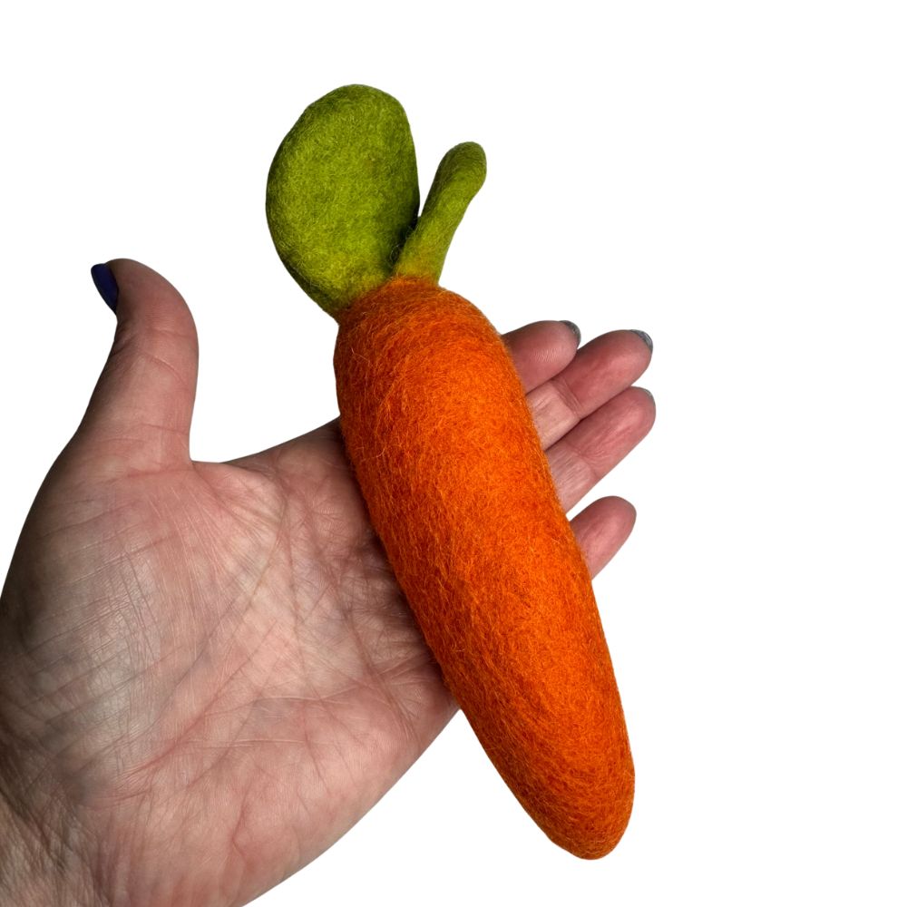 Medium wool carrot cat toy sprayed with catnip spray shown in hand for scale - Orange with Green leaves