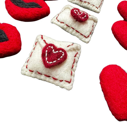 Close-up of handmade red wool lips cat toy with black felt detail, soft felted texture, sprayed with signature catnip. Wool toy by CatnipTakeout.